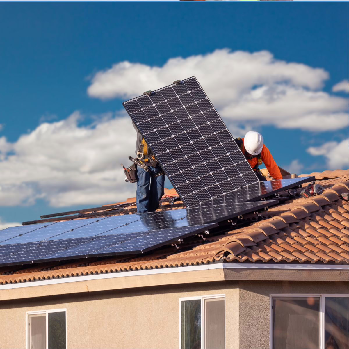 Experts install a solar panel on a client's roof before monsoon season. 
