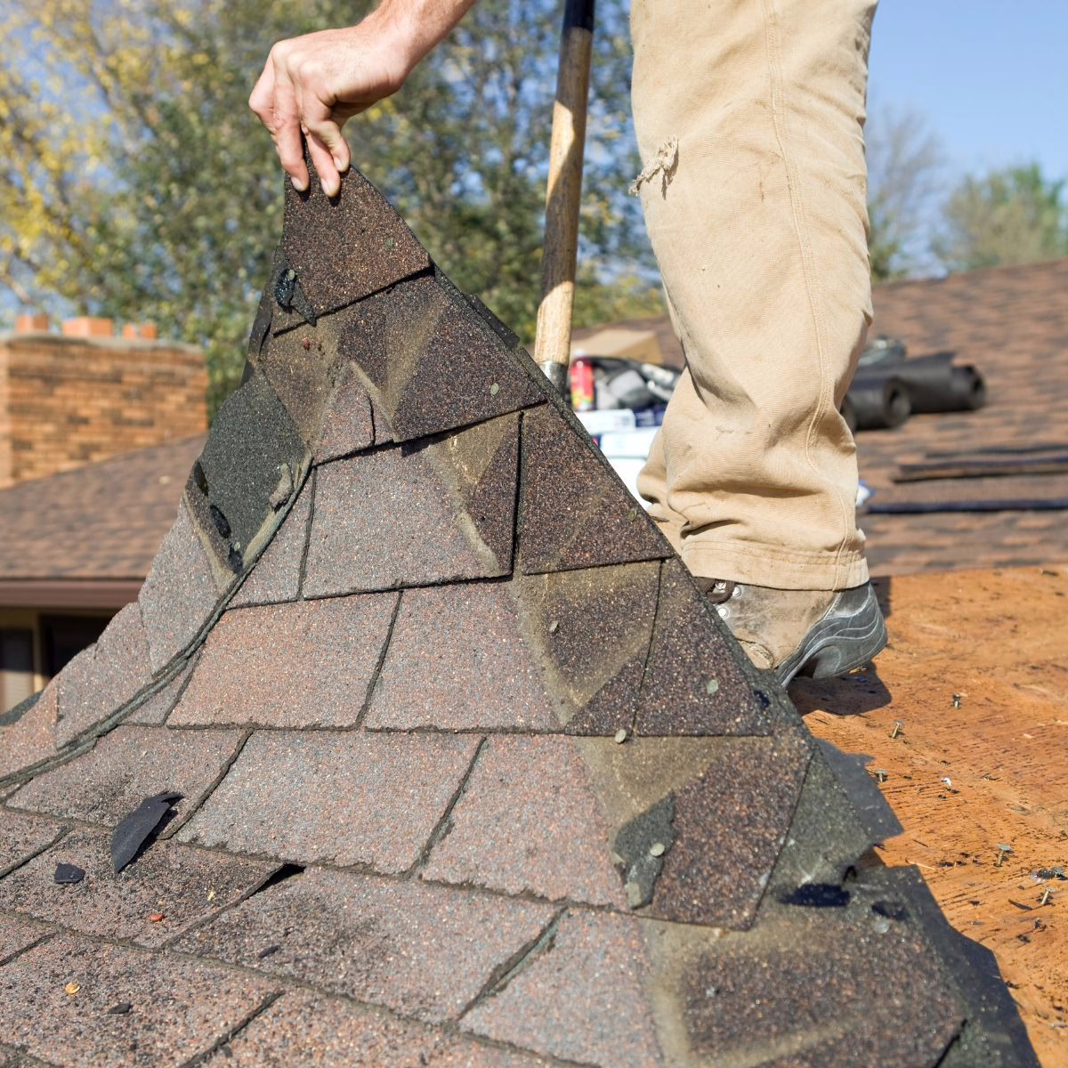 Roofing contractors removing the underlayment before starting a new installation. 