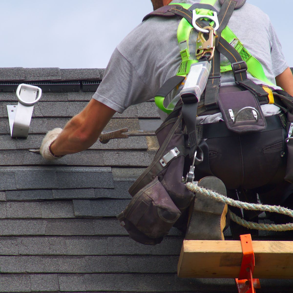 A shingle is installed by a roofing contractor. 