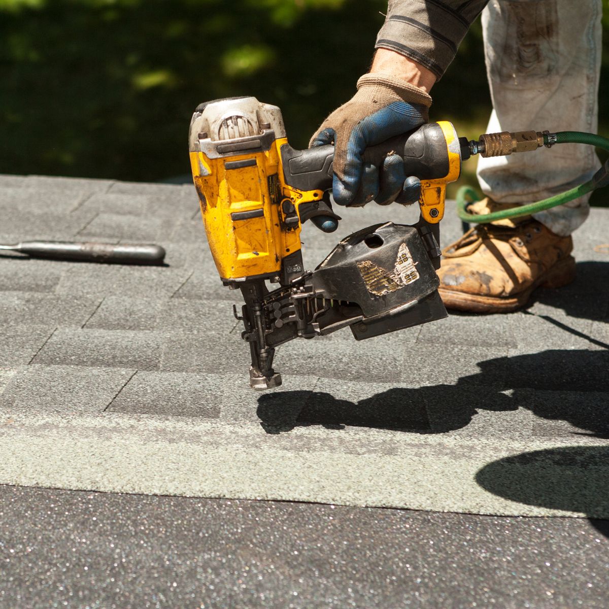 A shingle tile is being installed on the roof of a customer of Triumph Roofing. 